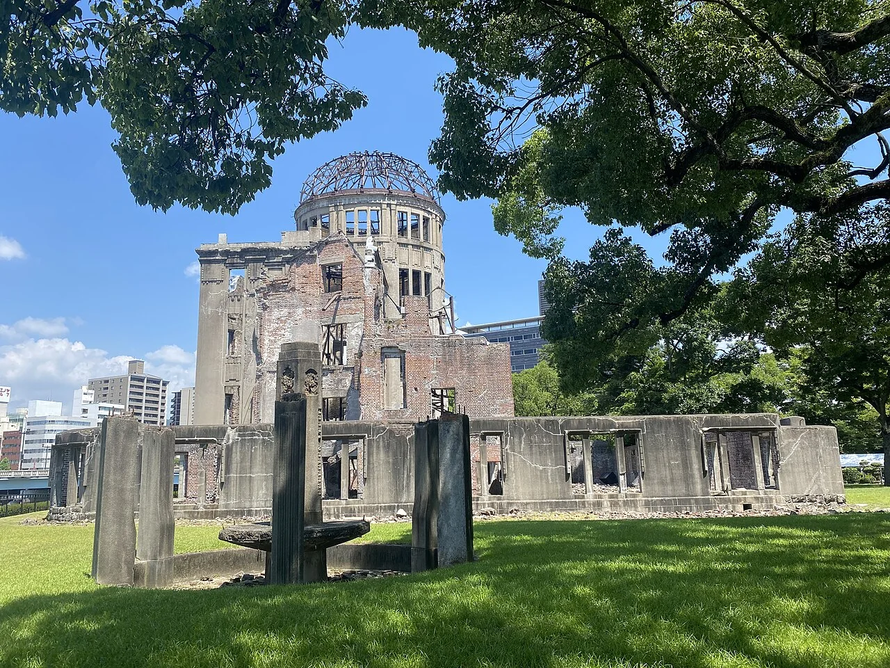 Cúpula da Bomba Atômica em Hiroshima, com a estrutura preservada e árvores ao redor.