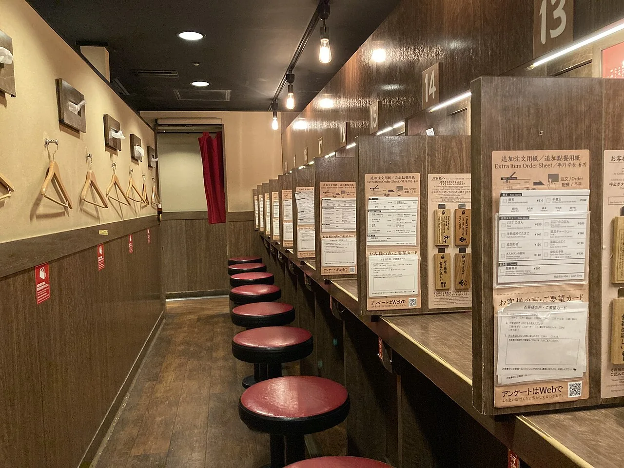 Balcão do Ichiran em Hakata com bancos individuais e divisórias entre os lugares.