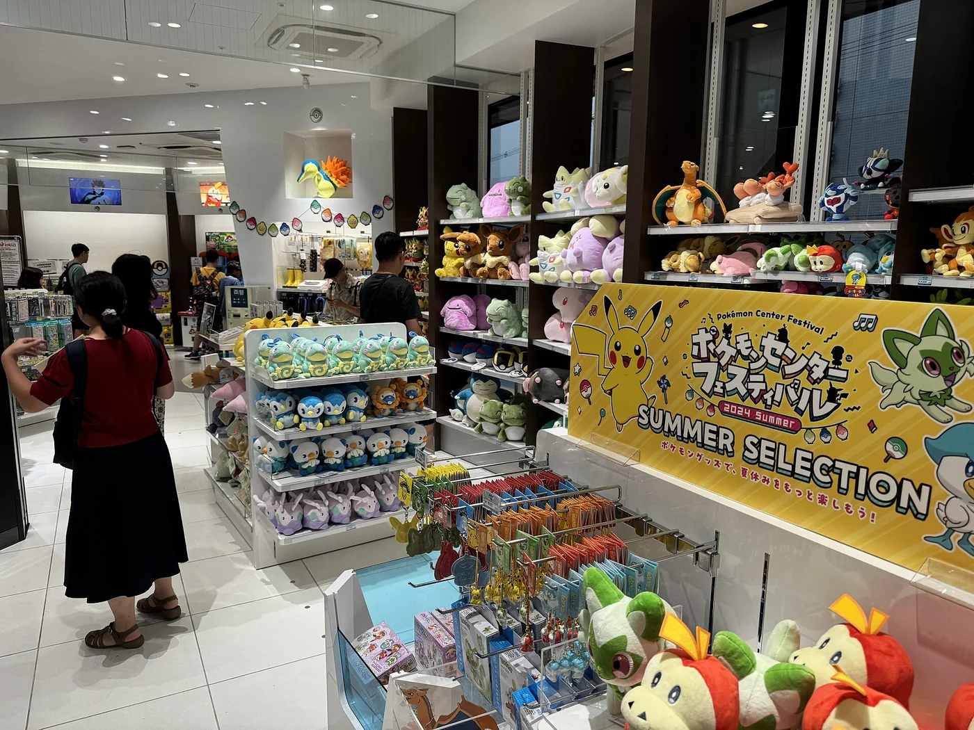 Prateleiras de pelúcias e produtos no Pokémon Center Kyoto.